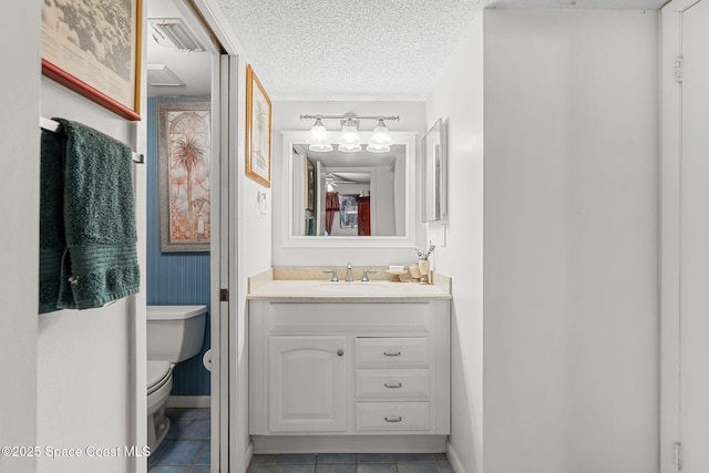 bathroom featuring toilet, baseboards, tile patterned flooring, and vanity