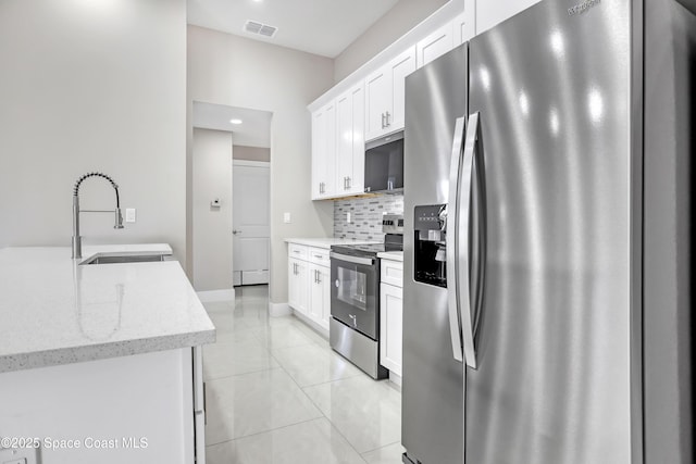 926 Sareta St SE, Palm Bay, FL 32909 - kitchen featuring appliances with stainless steel finishes, a sink, tasteful backsplash, white cabinets, and recessed lighting