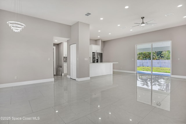 926 Sareta St SE, Palm Bay, FL 32909 - unfurnished living room featuring baseboards, a ceiling fan, recessed lighting, light tile patterned floors, and a chandelier