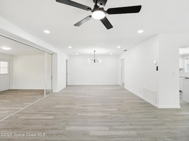 unfurnished room with recessed lighting, light wood-style floors, a chandelier, baseboards, and a ceiling fan
