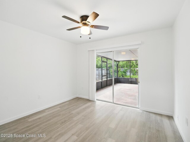empty room with wood finished floors, a ceiling fan, and baseboards