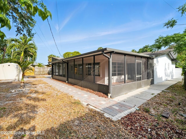 rear view of property with a sunroom and fence