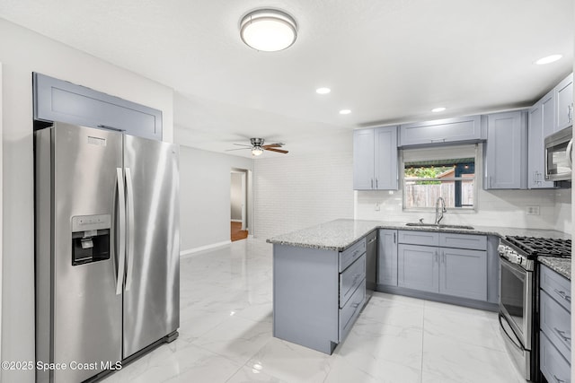 3845 Spring Creek Ln, Titusville, FL 32780 - kitchen featuring appliances with stainless steel finishes, a peninsula, light stone counters, a ceiling fan, and light marble finish floors