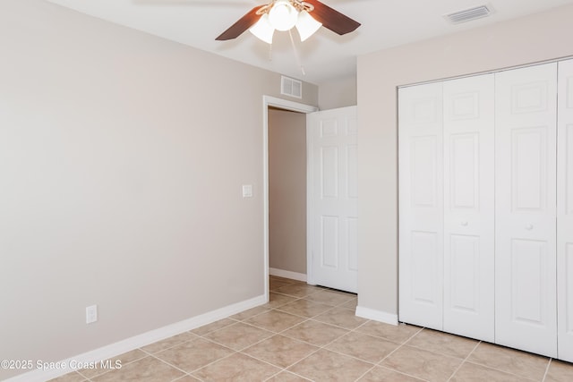 1610 Yahner St SE, Palm Bay, FL 32909 - unfurnished bedroom featuring light tile patterned floors, a closet, baseboards, and a ceiling fan