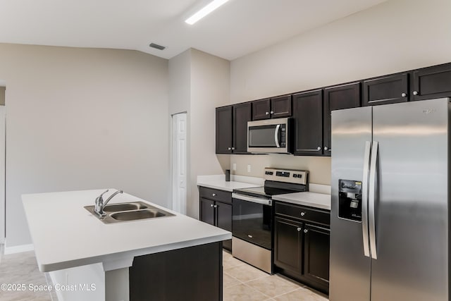 1610 Yahner St SE, Palm Bay, FL 32909 - kitchen with appliances with stainless steel finishes, a sink, light tile patterned floors, light countertops, and an island with sink
