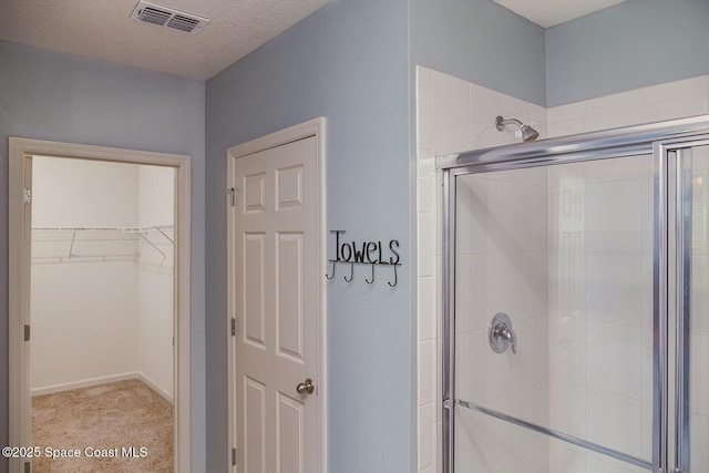 3847 Loggerhead Ln, Mims, FL 32754 - full bathroom featuring a shower stall, a spacious closet, and a textured ceiling