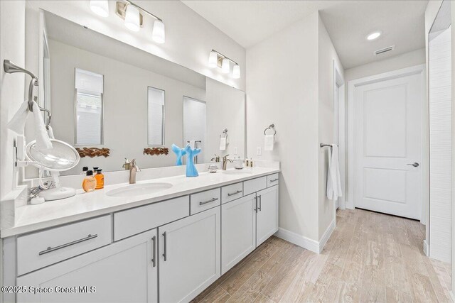 2902 Tidepool Pl, Melbourne, FL 32940 - full bath with wood finished floors, double vanity, and baseboards