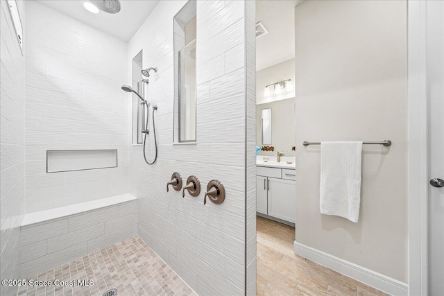 2902 Tidepool Pl, Melbourne, FL 32940 - bathroom featuring tiled shower, vanity, wood finished floors, and baseboards