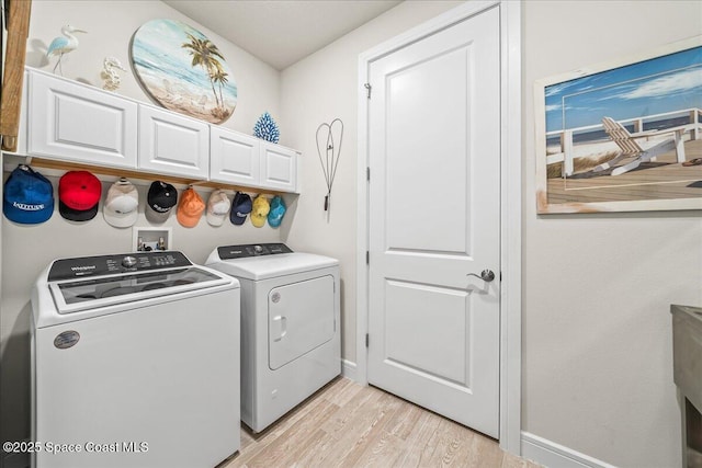2902 Tidepool Pl, Melbourne, FL 32940 - laundry area with washing machine and clothes dryer, light wood finished floors, baseboards, and cabinet space