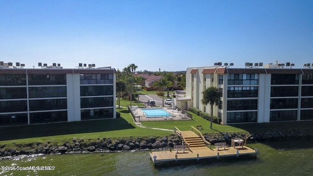 dock with a yard, a community pool, and a water view
