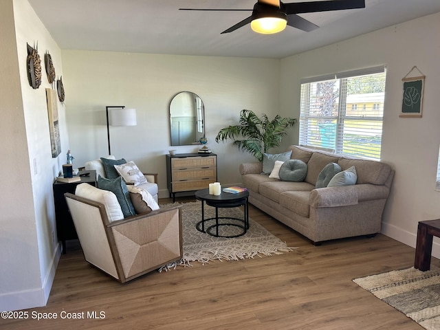living room featuring wood finished floors, a ceiling fan, and baseboards