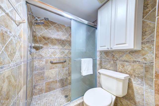 bathroom featuring a stall shower and toilet