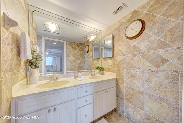 full bathroom with tile walls and double vanity