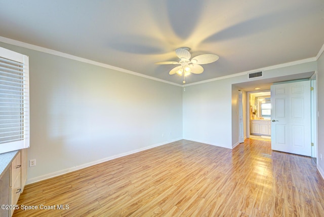 empty room with light wood-style flooring, a ceiling fan, baseboards, and ornamental molding