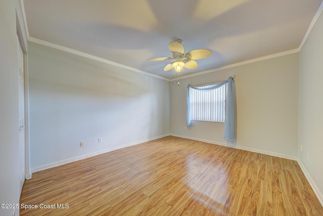 empty room with wood finished floors, ceiling fan, ornamental molding, and baseboards