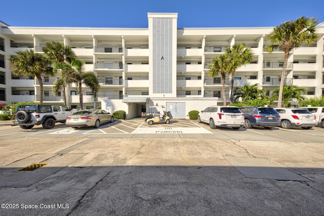 view of apartment building / complex with uncovered parking