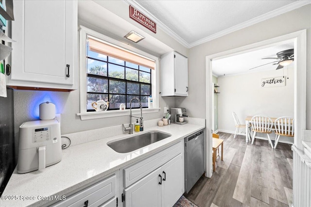 kitchen with a sink, stainless steel dishwasher, ornamental molding, white cabinetry, and ceiling fan