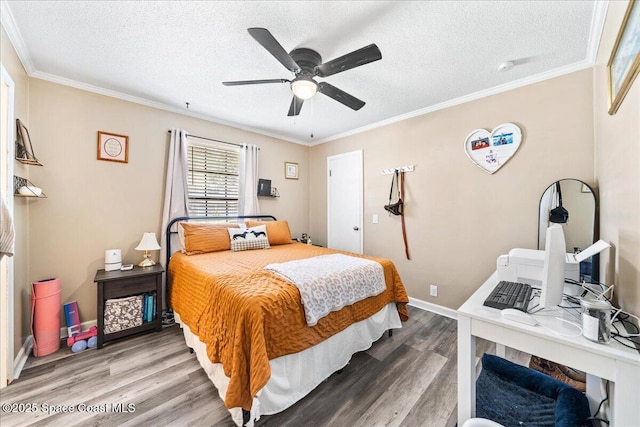 bedroom featuring wood finished floors, a textured ceiling, crown molding, ceiling fan, and baseboards