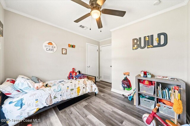 bedroom featuring wood finished floors, ornamental molding, baseboards, and a ceiling fan