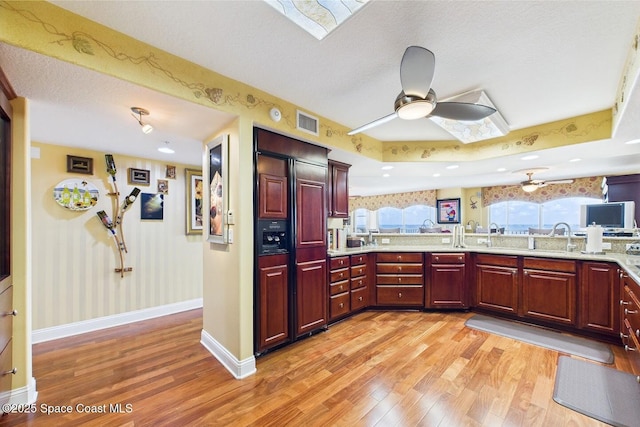732 Bayside Dr Unit 501, Cape Canaveral, FL 32920 - kitchen with light wood-style floors, a skylight, paneled fridge, baseboards, and a textured ceiling