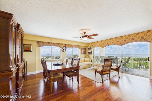 732 Bayside Dr Unit 501, Cape Canaveral, FL 32920 - dining space featuring dark wood-type flooring, a ceiling fan, a textured ceiling, and baseboards