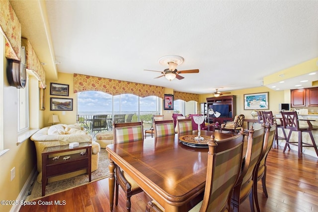 732 Bayside Dr Unit 501, Cape Canaveral, FL 32920 - dining room featuring dark wood-style flooring, ceiling fan, and baseboards