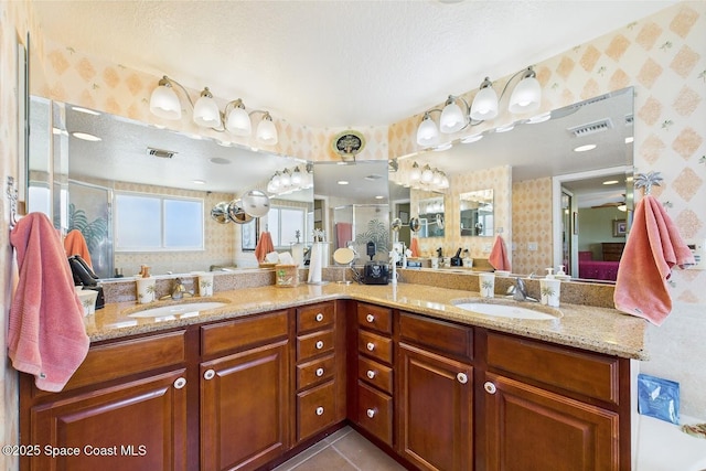 732 Bayside Dr Unit 501, Cape Canaveral, FL 32920 - bathroom with wallpapered walls, a stall shower, double vanity, and a textured ceiling