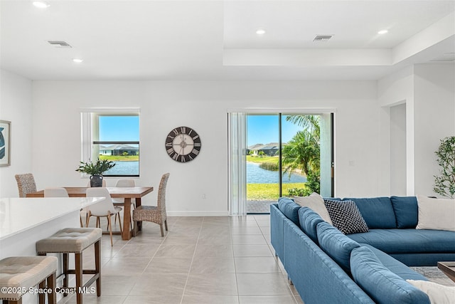 1342 Great Belt Cir, Melbourne, FL 32940 - living area with a water view, recessed lighting, a raised ceiling, light tile patterned floors, and baseboards