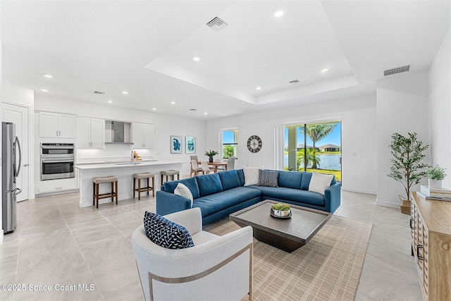 1342 Great Belt Cir, Melbourne, FL 32940 - living area featuring recessed lighting, a raised ceiling, light tile patterned flooring, and baseboards