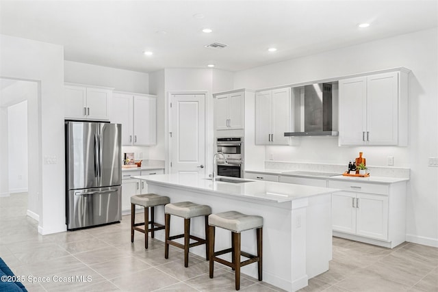 1342 Great Belt Cir, Melbourne, FL 32940 - kitchen with stainless steel appliances, wall chimney exhaust hood, white cabinetry, a breakfast bar, and an island with sink