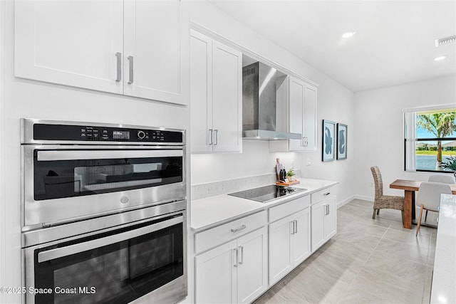 1342 Great Belt Cir, Melbourne, FL 32940 - kitchen featuring wall chimney exhaust hood, stainless steel double oven, light countertops, white cabinets, and recessed lighting