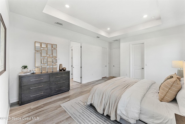 1342 Great Belt Cir, Melbourne, FL 32940 - bedroom with a raised ceiling, light wood-type flooring, recessed lighting, and baseboards