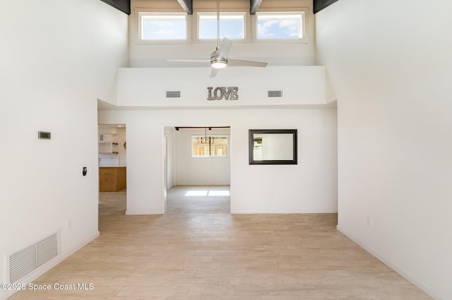 hall featuring a high ceiling, wood finished floors, and baseboards