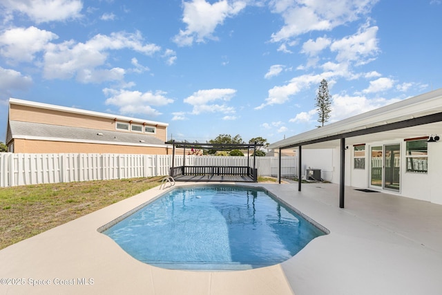 view of pool featuring a patio, a fenced backyard, and central AC