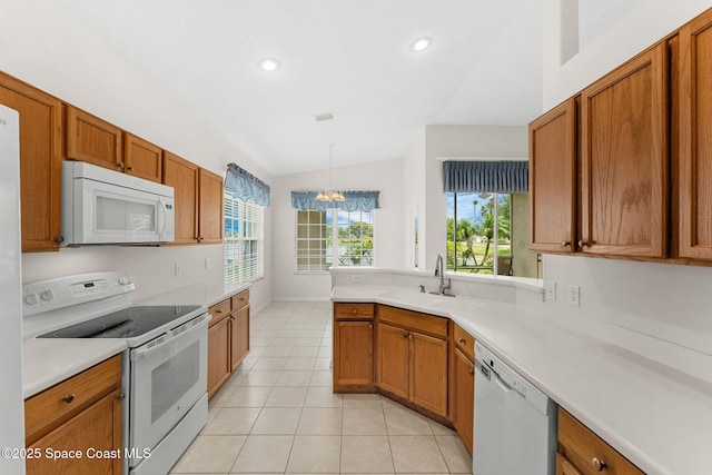 4882 Worthington Cir, Rockledge, FL 32955 - kitchen featuring white appliances, a sink, lofted ceiling, brown cabinets, and light tile patterned floors
