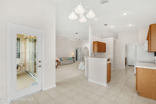 4882 Worthington Cir, Rockledge, FL 32955 - kitchen featuring white microwave, brown cabinets, light countertops, open floor plan, and a peninsula