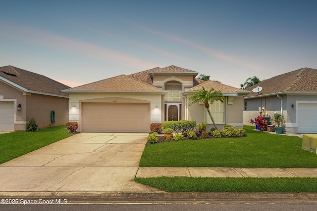 4882 Worthington Cir, Rockledge, FL 32955 - mediterranean / spanish house featuring stucco siding, a garage, concrete driveway, and a front yard