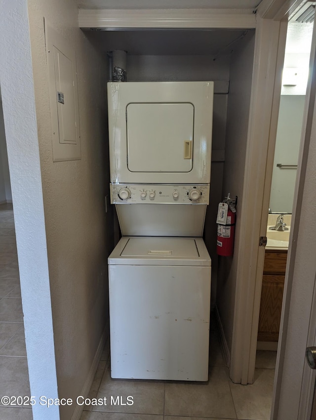 1600 University Ln Unit 1504, Cocoa, FL 32922 - washroom with estacked washer and dryer, electric panel, light tile patterned floors, and baseboards
