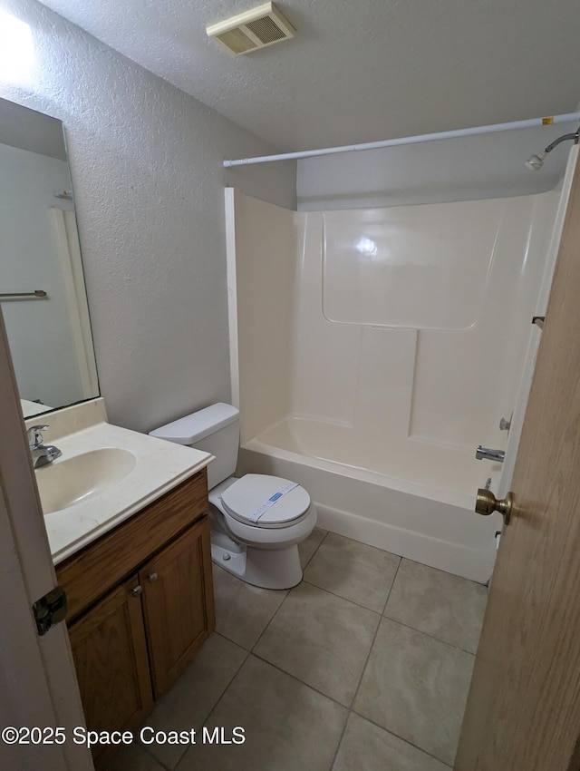 1600 University Ln Unit 1504, Cocoa, FL 32922 - full bathroom with a textured wall, toilet, tile patterned floors, vanity, and bathing tub / shower combination