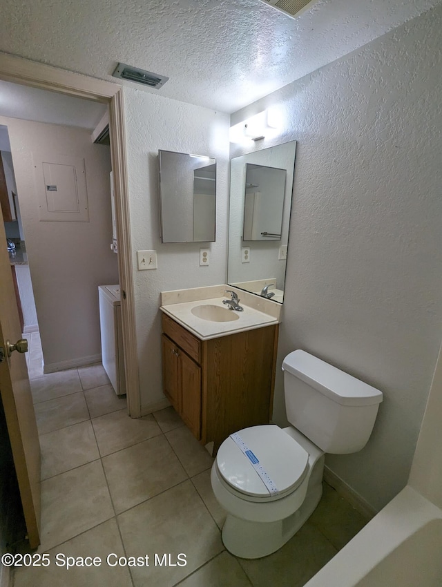 1600 University Ln Unit 1504, Cocoa, FL 32922 - bathroom with tile patterned flooring, toilet, vanity, a textured wall, and a textured ceiling