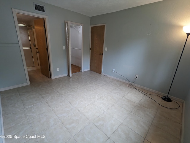 1600 University Ln Unit 1504, Cocoa, FL 32922 - unfurnished bedroom with a spacious closet, light tile patterned floors, baseboards, and a closet