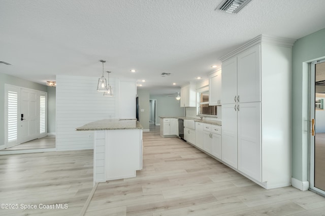 kitchen with white cabinets, light stone countertops, dishwasher, light wood finished floors, and baseboards