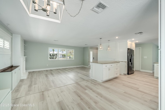 kitchen featuring black refrigerator with ice dispenser, open floor plan, white cabinets, light wood-type flooring, and recessed lighting