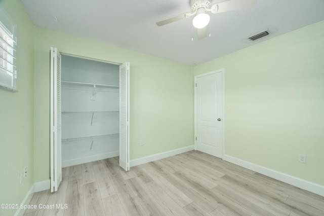unfurnished bedroom with wood finished floors, baseboards, a closet, and a ceiling fan