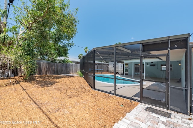 view of swimming pool featuring a fenced backyard, a patio, and a lanai
