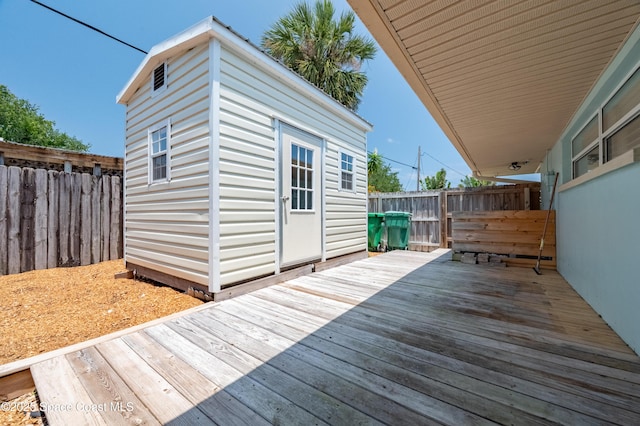 wooden deck with an outdoor structure and a fenced backyard