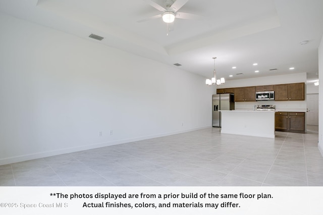 125 Admiral Cir, Sebastian, FL 32958 - unfurnished living room with a chandelier, recessed lighting, a ceiling fan, a tray ceiling, and baseboards