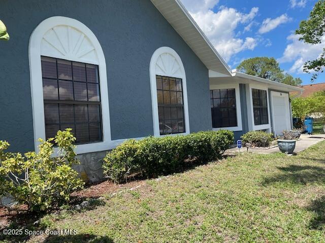 view of property exterior with a yard and stucco siding