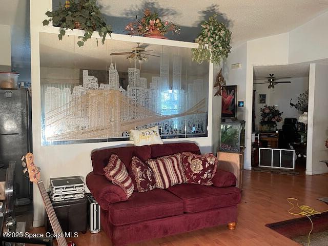 living area featuring a ceiling fan and wood finished floors