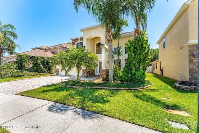 mediterranean / spanish house featuring driveway, stucco siding, and a front yard